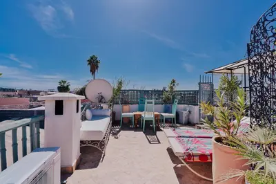 a balcony with a table and chairs on a roof at Riad Manaoui in Marrakech