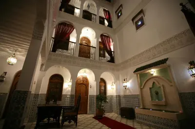 a lobby of a building with a table and chairs at Riad Mouna in Marrakech