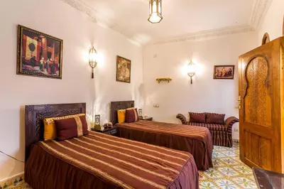 a hotel room with two beds and a couch at Riad Mouna in Marrakech