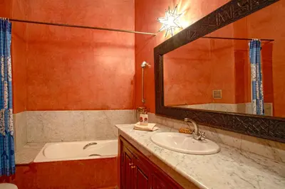 a bathroom with a sink and a tub and a mirror at Riad Lakhdar in Marrakech