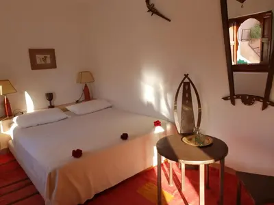 a bedroom with a bed and a table and a mirror at Dar Warda in Marrakech