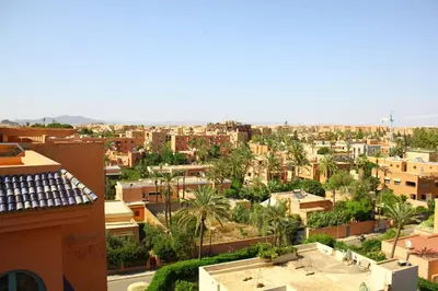 a view of a city with palm trees and buildings at El Hamra Hotel in Marrakech