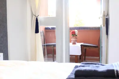 a bedroom with a bed and a table and a window at El Hamra Hotel in Marrakech