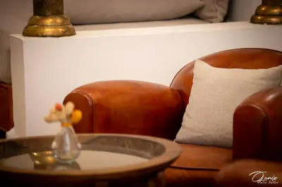 a leather chair and a table with a vase of flowers on it at Riad Zoraida in Marrakech