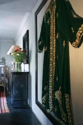 a robe hanging on a wall next to a mirror at Riad Golfame in Marrakech