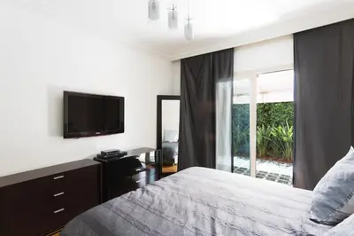 a bedroom with a bed and a tv and a window at The Ruby Apartment with Private Swimming Pool - Hivernage Quarter - By Goldex Marrakech in Marrakech