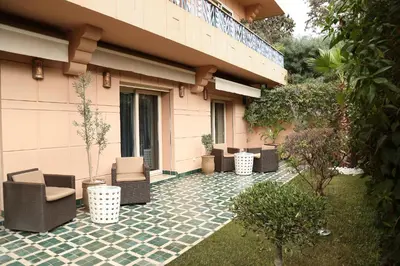 a patio with chairs and plants in front of a building at The Ruby Apartment with Private Swimming Pool - Hivernage Quarter - By Goldex Marrakech in Marrakech