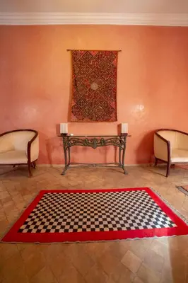 a room with a table and a checkered rug at Riad AKL in Marrakech