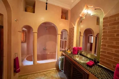 a bathroom with a shower and a sink and a tub at Riad AKL in Marrakech
