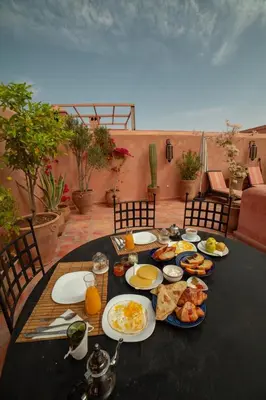 a table with plates of breakfast food on it at Riad AKL in Marrakech
