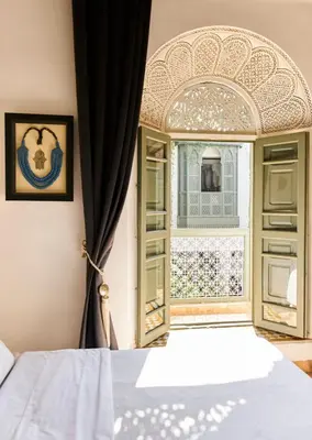 a bedroom with a bed and an open window at Riad Rafaele & SPA in Marrakech