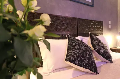 a bed with black and white pillows on it at Riad Marrakiss in Marrakech