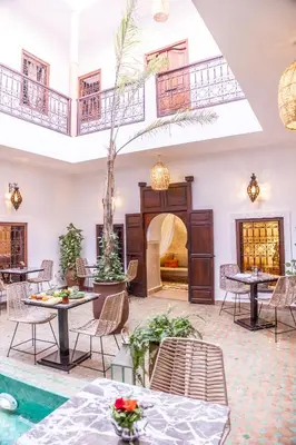 a lobby with tables and chairs and a pool at Riad Dar Elma And Spa in Marrakech