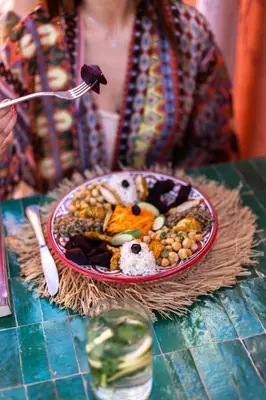 a woman sitting at a table with a plate of food at Riad Dar Elma And Spa in Marrakech