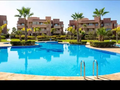 a large swimming pool in front of a building at Marrakech golf City prestigia in Marrakech