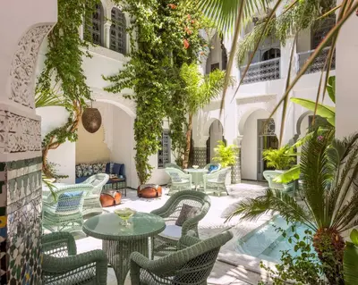 a courtyard with tables and chairs and plants at Riad Idra in Marrakech