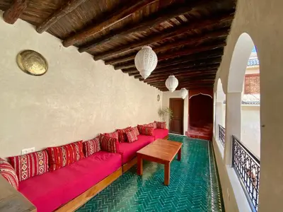 a living room with a red couch and a wooden table at Riad Prada in Marrakech