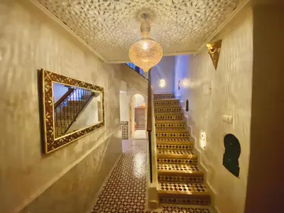 a hallway with stairs and a mirror on the wall at Riad Prada in Marrakech