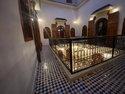 a hallway with a wrought iron railing and a tiled floor at Riad Prada in Marrakech