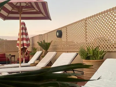 a group of chairs and an umbrella on a patio at Riad Prada in Marrakech