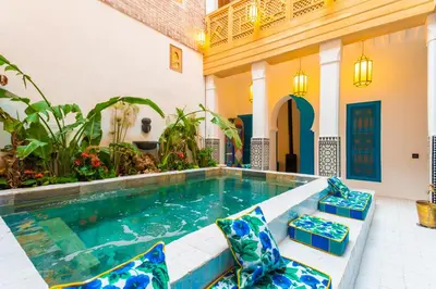 a swimming pool in a house with blue and white at Riad Tibibt in Marrakech