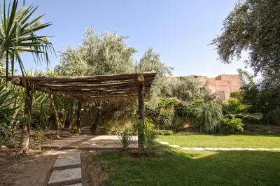 a wooden pergola in a garden at Villa Berbère Domaine des Kasbahs in Marrakech