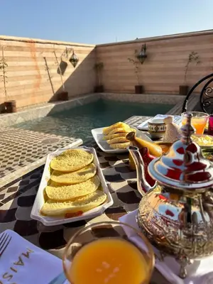 a table with a tray of food next to a swimming pool at Maison Do in Marrakech