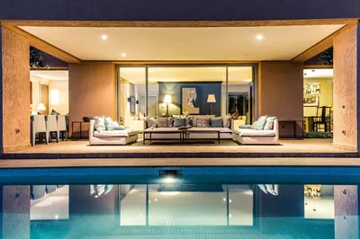 a house with a swimming pool and a living room at Al Maaden 132 - Luxury front line golf villa with heated pool in Marrakech