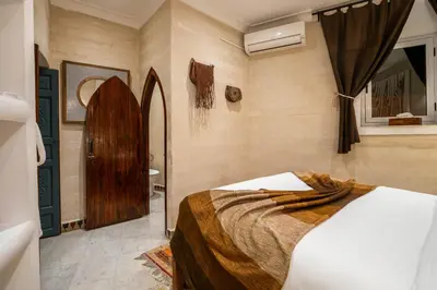 a bedroom with a bed and a bathroom at Dar Alhambra Riad Medina in Marrakech