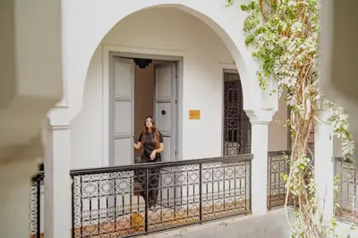 a woman standing on the balcony of a house at Outsite Marrakesh in Marrakech