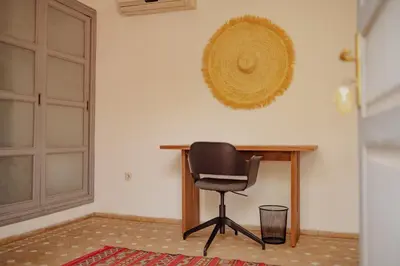a black chair sitting next to a wooden desk at Outsite Marrakesh in Marrakech
