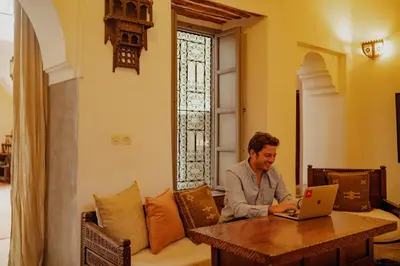 a man sitting at a table with a laptop at Outsite Marrakesh in Marrakech