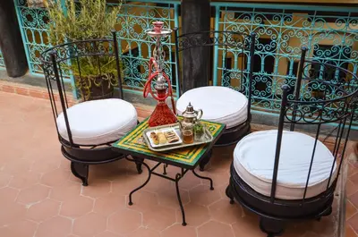 two chairs and a table with a tea set on it at Riad Ben Tachfine in Marrakech