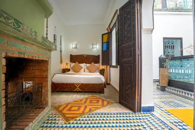 a bedroom with a bed and a fireplace at Riad Ben Tachfine in Marrakech