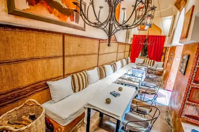 a room with couches and tables and a chandelier at Riad Chorfa in Marrakech