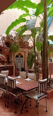 a table and chairs with a table and trees at Riad Dar Mchicha in Marrakech