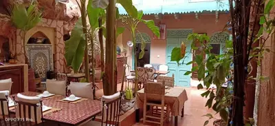 a restaurant with tables and chairs and plants at Riad Dar Mchicha in Marrakech