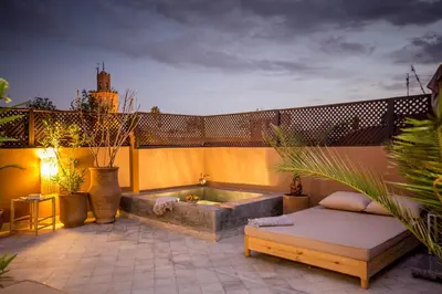 a patio with a hot tub and a couch at Riad Olema et Spa in Marrakech