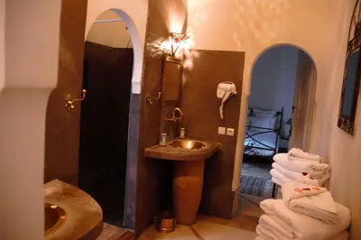 a bathroom with a sink and a mirror at Riad Dar El Gnaouia in Marrakech