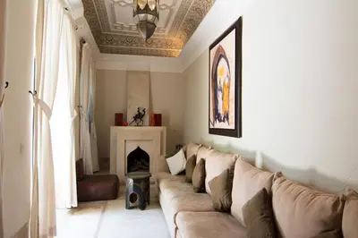a living room with a couch and a fireplace at Riad Dar El Gnaouia in Marrakech