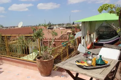 a table with a plate of food on a balcony at Riad Eloise in Marrakech