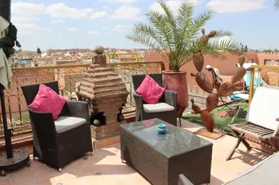 a patio with chairs and a fireplace on a balcony at Riad Eloise in Marrakech