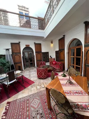 a large room with tables and chairs and a ceiling at Riad Villa El Arsa in Marrakech
