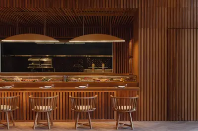 a restaurant with chairs and a counter with food at Nobu Hotel Marrakech in Marrakech