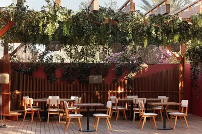 a patio with tables and chairs and plants at Nobu Hotel Marrakech in Marrakech