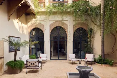 a patio with chairs and tables in front of a building at Nobu Hotel Marrakech in Marrakech