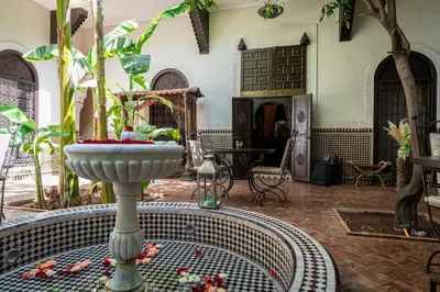 a living room with a fountain in the middle of a room at Riad ILayka in Marrakech