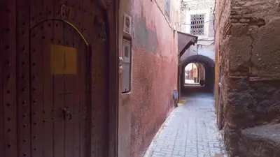 an alley with a door and an arch way at Riad Le J in Marrakech