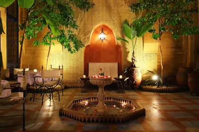 a living room with a fireplace and a table with candles at Riad Soundouss in Marrakech