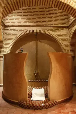 a room with a large brick fireplace with a table at Riad Soundouss in Marrakech